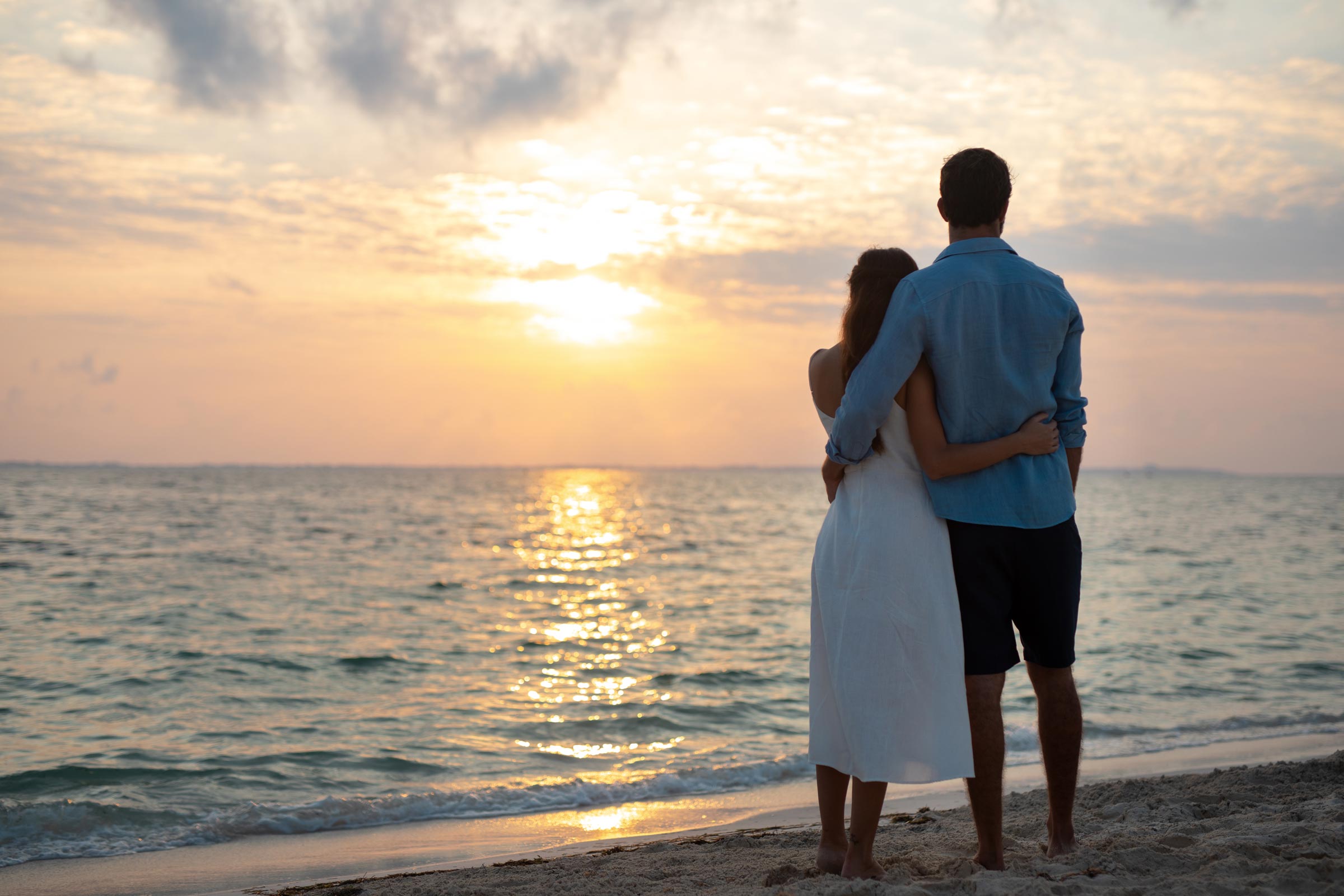 Romantic couple enjoying moments together on their honeymoon as they watch the sunrise 