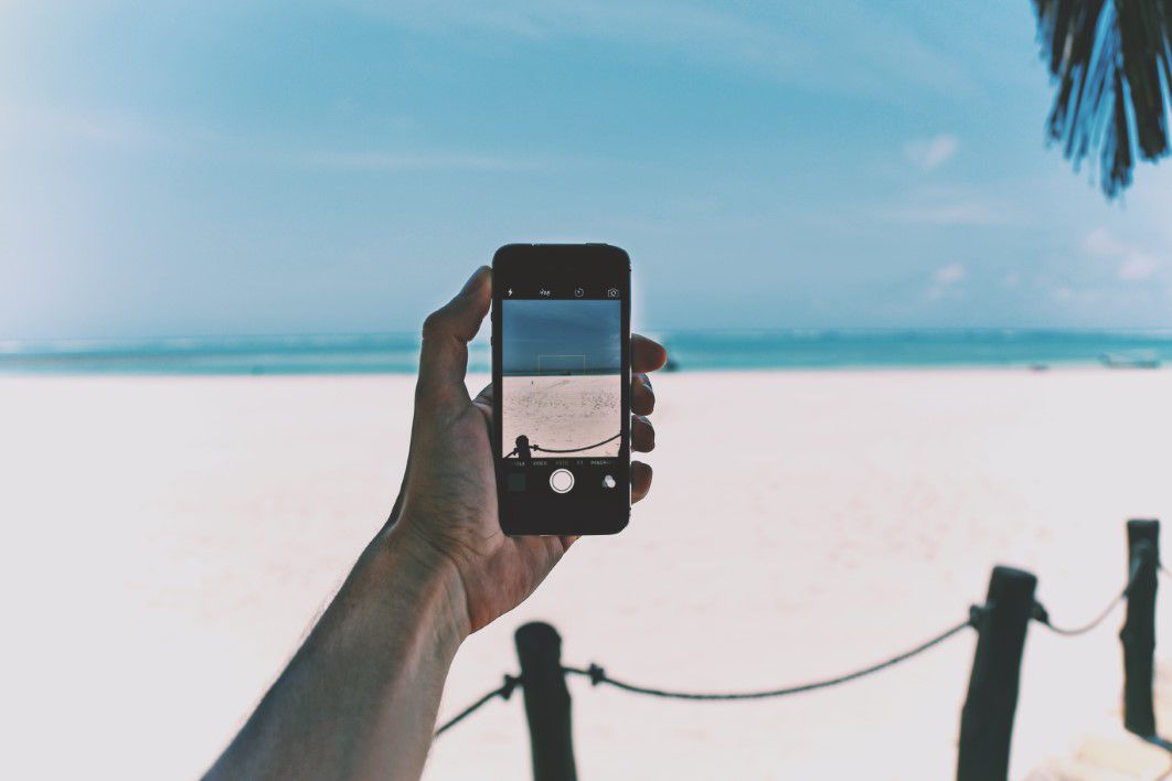 Phone taking a photo of the white sands of Cancun Phone taking a photo of the white sands of Cancun